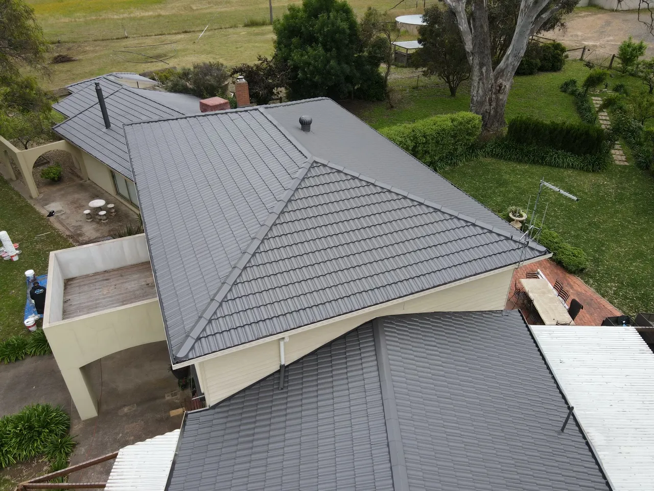 Close view of recoated concrete roof tiles with even ridge and hip capping, tile roofing work in the Bendigo region